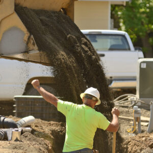 Excavation contractors installing water lines in a utility trench at a commercial residential development Excavation contractors installing water lines in a utility trench at a commercial residential development
